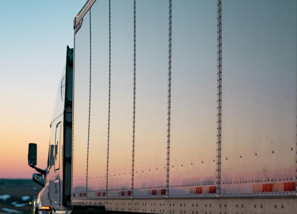 Aluminum dry van trailer on a highway at dusk