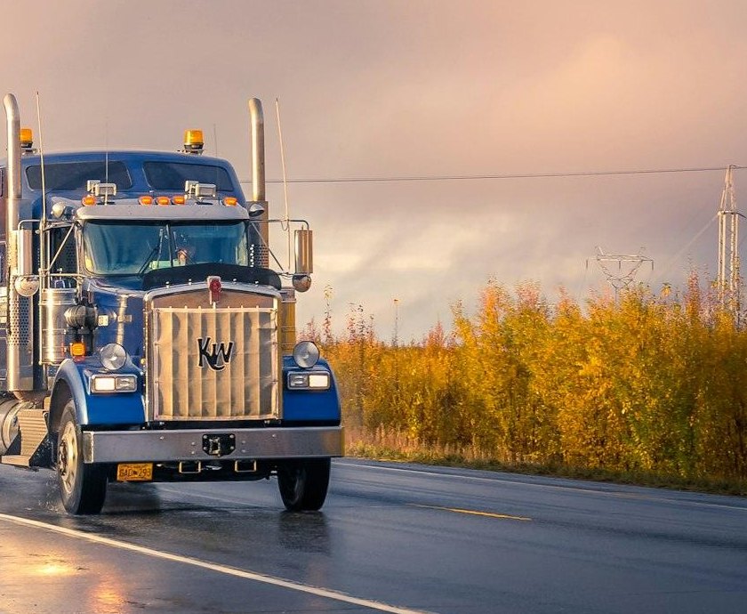 Kenworth flatbed truck on a wet highway