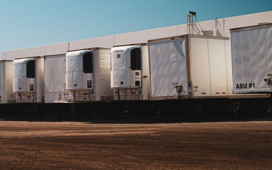 Refrigerated trailers with cooling units parked at a warehouse